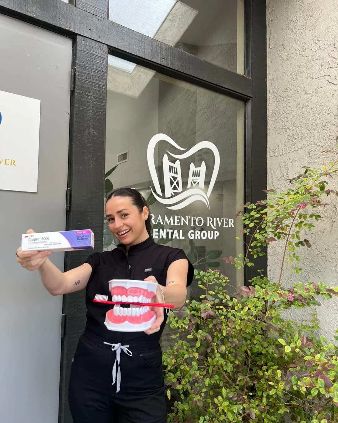 Dental hygienist standing in the office doorway holding a teeth whitening kit